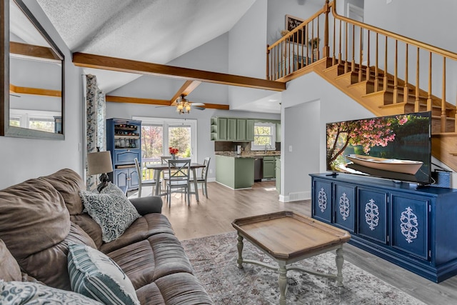 living room with light wood-style floors, high vaulted ceiling, stairway, and a ceiling fan