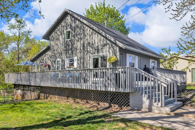rear view of property with a lawn and a wooden deck