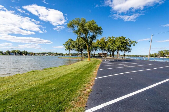 uncovered parking lot featuring a water view