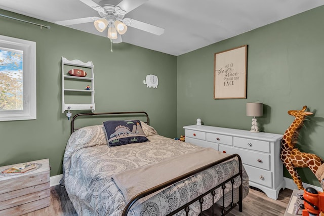 bedroom featuring light wood-type flooring, a ceiling fan, and baseboards