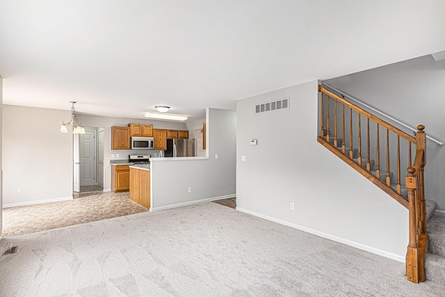 unfurnished living room featuring visible vents, stairs, baseboards, light colored carpet, and a chandelier