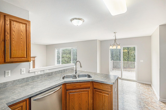 kitchen with brown cabinets, a wealth of natural light, a sink, and dishwasher