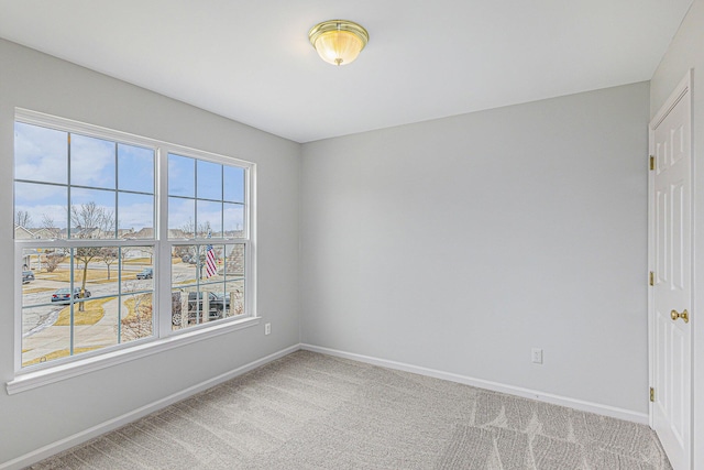 unfurnished room with carpet floors and baseboards