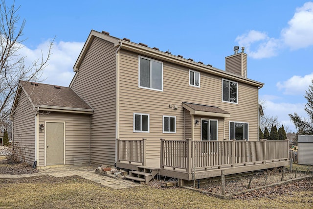 rear view of property with a chimney and a wooden deck