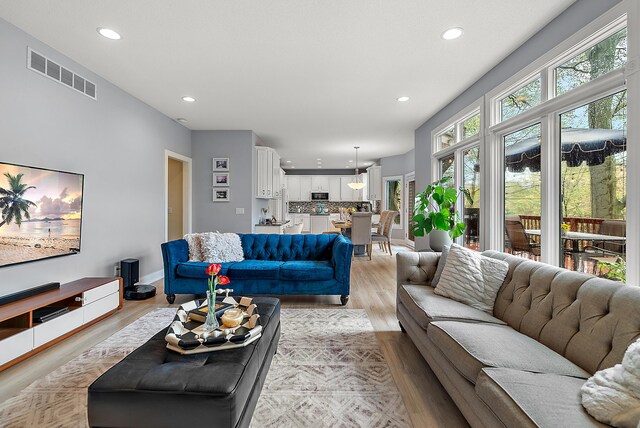living room with visible vents, recessed lighting, and light wood-type flooring