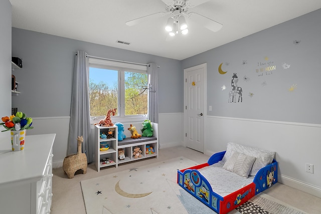 recreation room featuring baseboards, light carpet, a ceiling fan, and visible vents