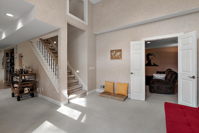 staircase with visible vents, baseboards, a high ceiling, carpet, and recessed lighting