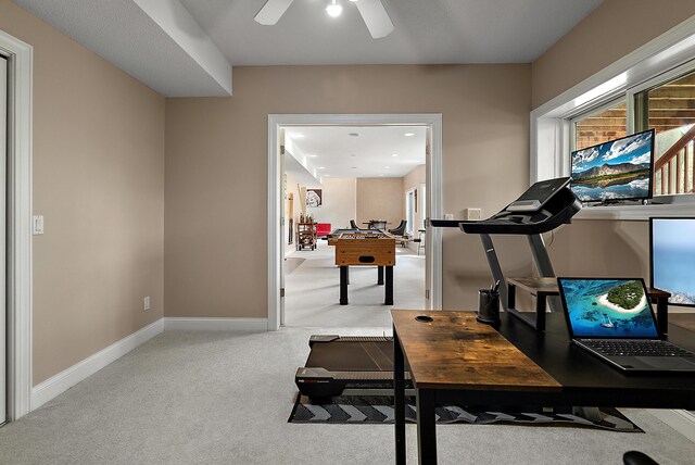 exercise room with baseboards, ceiling fan, and carpet flooring