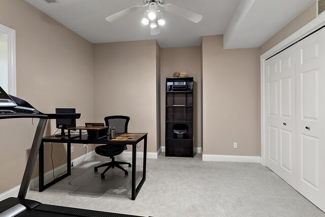 office space featuring a ceiling fan, baseboards, and carpet