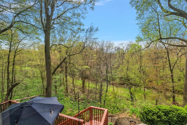 view of yard with a view of trees and a wooden deck