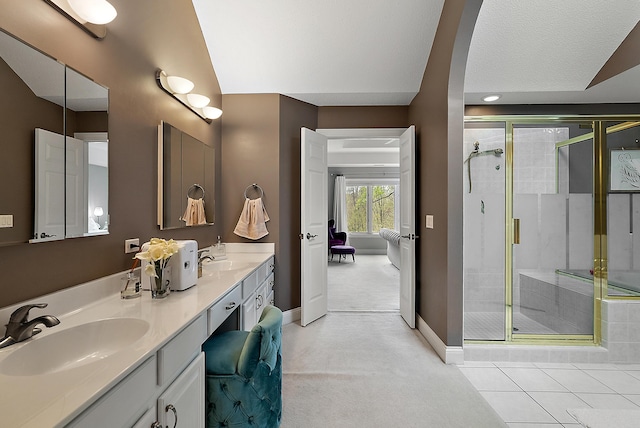 full bathroom featuring baseboards, a sink, and a shower stall