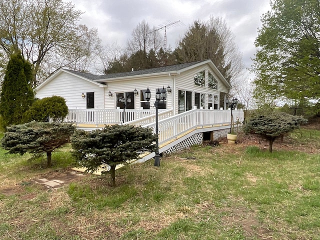 back of house with a deck and a shingled roof