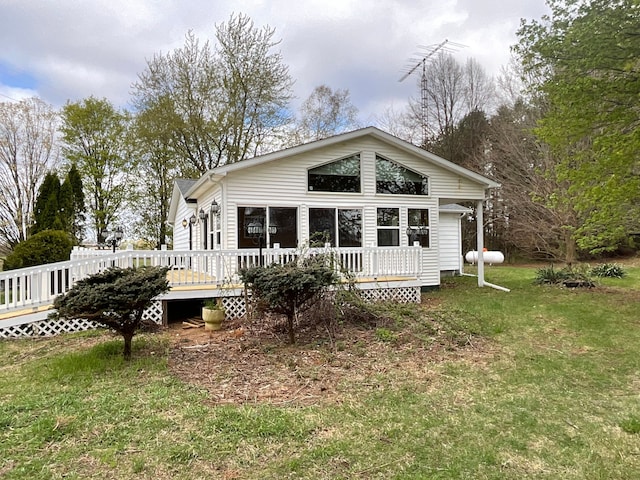 back of property featuring a lawn and a deck