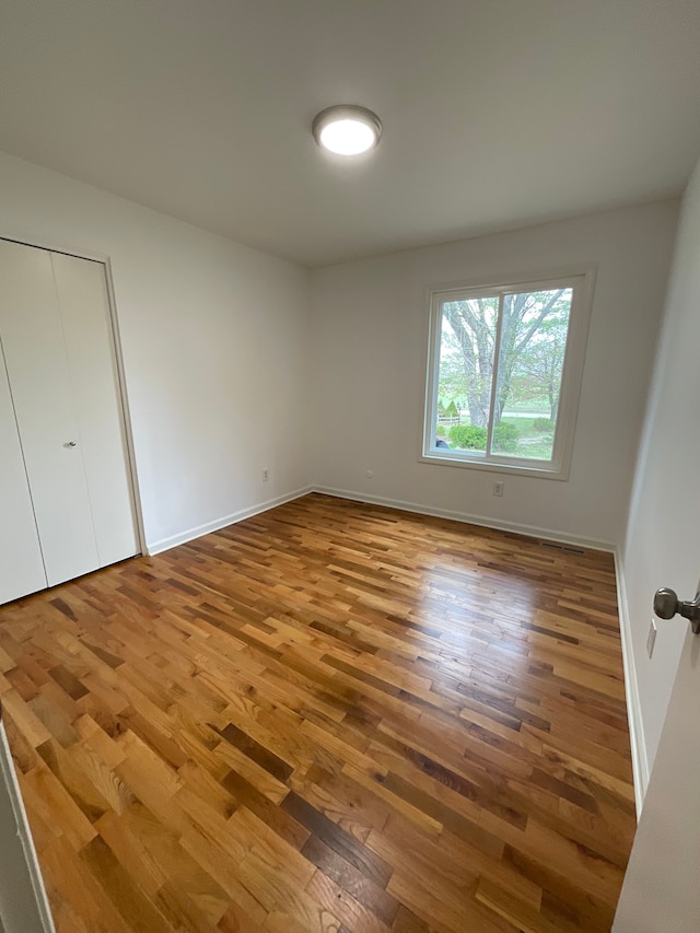 unfurnished bedroom featuring baseboards and wood finished floors