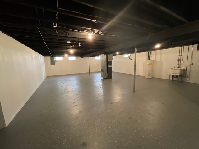 unfinished below grade area with a sink and water heater