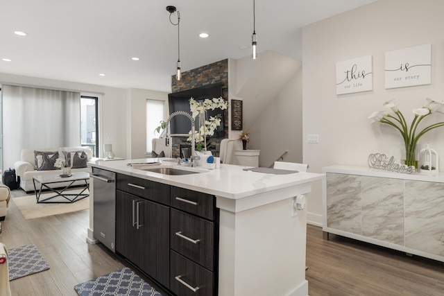 1049 Hampton Cir Unit 44, Detroit, MI 48207 - kitchen with a sink, open floor plan, a kitchen island with sink, dark wood-style flooring, and light countertops
