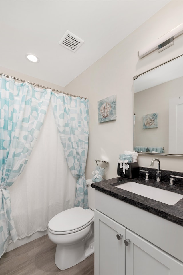 1049 Hampton Cir Unit 44, Detroit, MI 48207 - bathroom with recessed lighting, toilet, visible vents, vanity, and wood finished floors
