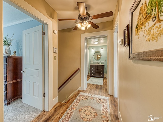6603 S Stony Creek Rd, Monroe, MI 48162 - corridor featuring baseboards, light wood-style flooring, and an upstairs landing