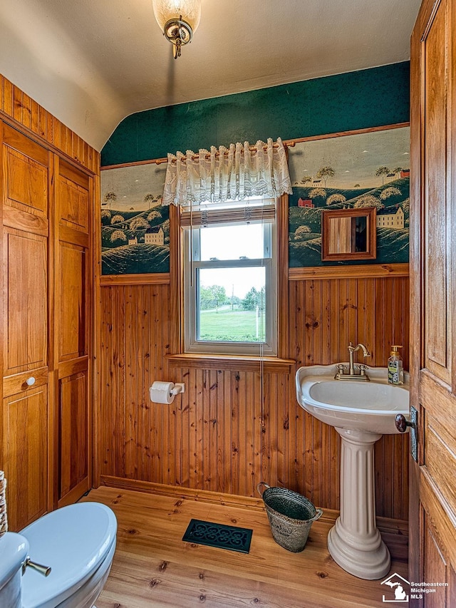 6603 S Stony Creek Rd, Monroe, MI 48162 - bathroom with toilet, wood walls, wood finished floors, and vaulted ceiling