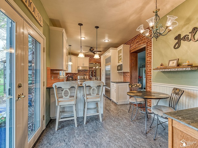 6603 S Stony Creek Rd, Monroe, MI 48162 - dining space featuring plenty of natural light, wainscoting, and a notable chandelier
