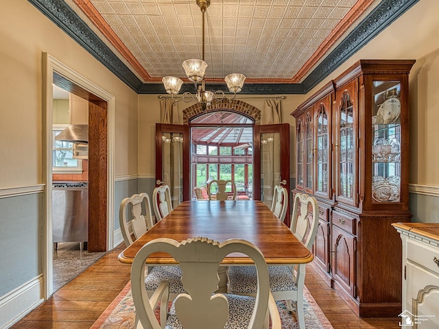 6603 S Stony Creek Rd, Monroe, MI 48162 - dining room with an inviting chandelier, an ornate ceiling, ornamental molding, and hardwood / wood-style flooring