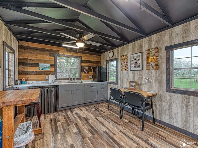 6603 S Stony Creek Rd, Monroe, MI 48162 - kitchen with vaulted ceiling with beams, wood walls, gray cabinets, and wood finished floors