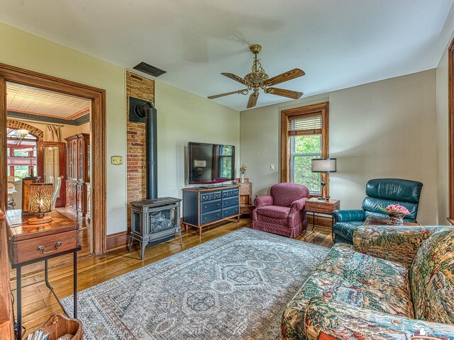 6603 S Stony Creek Rd, Monroe, MI 48162 - living area with ceiling fan, visible vents, wood finished floors, and a wood stove