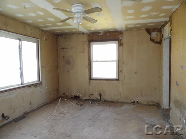 spare room featuring ceiling fan and a wealth of natural light