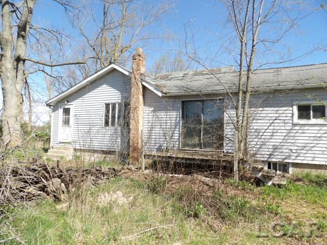 view of side of home with entry steps and a chimney