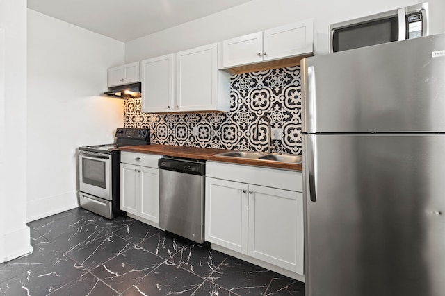 109 Leicester Ct, Detroit, MI 48202 - kitchen featuring stainless steel appliances, wooden counters, under cabinet range hood, dark marble finish flooring, and white cabinetry