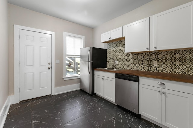 109 Leicester Ct, Detroit, MI 48202 - kitchen featuring appliances with stainless steel finishes, wooden counters, a sink, baseboards, and tasteful backsplash