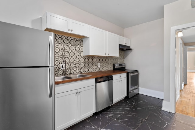 109 Leicester Ct, Detroit, MI 48202 - kitchen featuring appliances with stainless steel finishes, a sink, under cabinet range hood, butcher block countertops, and decorative backsplash