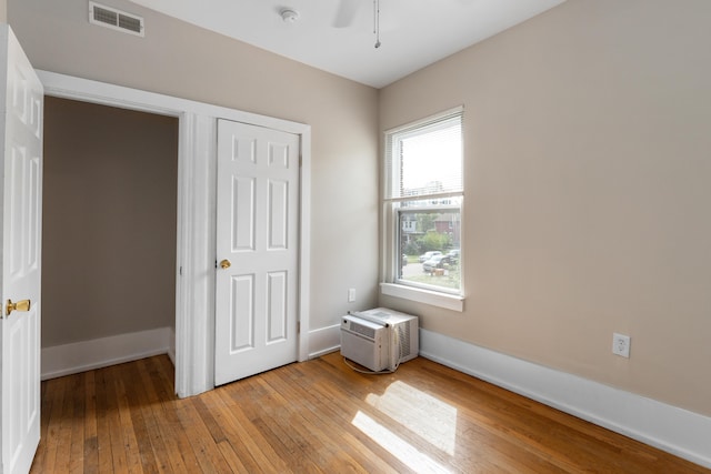 109 Leicester Ct, Detroit, MI 48202 - unfurnished bedroom with light wood-style floors, a wall mounted air conditioner, and baseboards