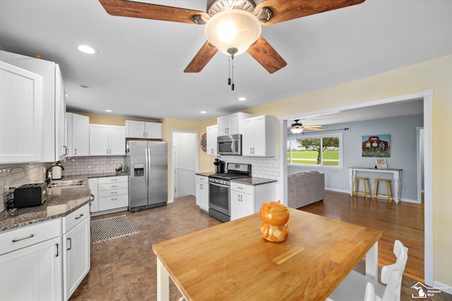 485 W Samaria Rd, Temperance, MI 48182 - kitchen with decorative backsplash, a sink, white cabinetry, a ceiling fan, and stainless steel appliances