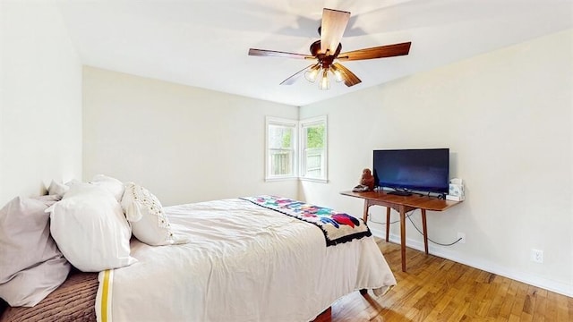 bedroom with baseboards, ceiling fan, and wood finished floors