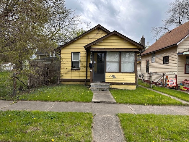 view of front of home with entry steps and a front lawn