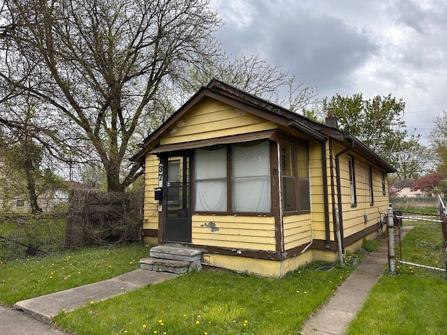 view of front of house with a front yard, fence, and entry steps