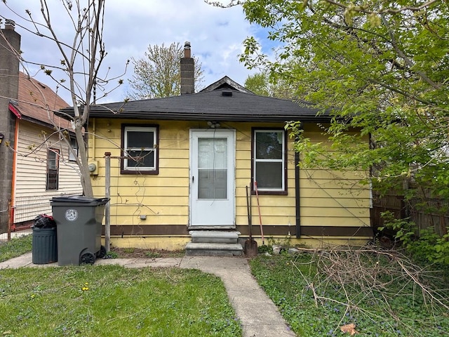 exterior space with fence, a front yard, a chimney, and entry steps