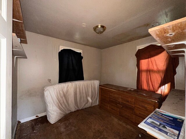 bedroom featuring baseboards and concrete floors