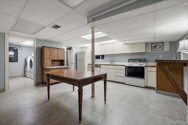 62 Robertson Ct, Clarkston, MI 48346 - kitchen with separate washer and dryer, white appliances, a sink, a paneled ceiling, and light countertops