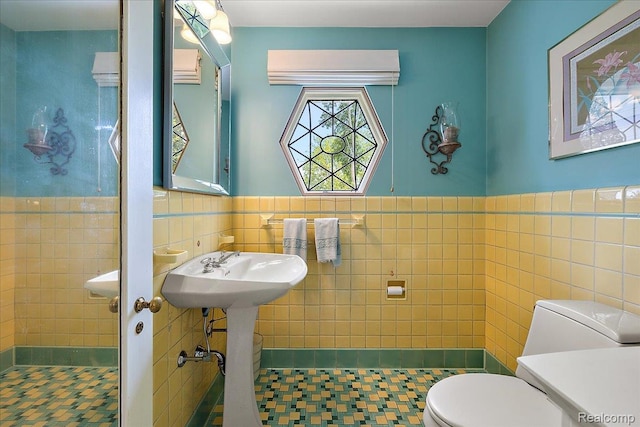 62 Robertson Ct, Clarkston, MI 48346 - full bathroom with toilet, tile walls, wainscoting, tile patterned floors, and a tile shower