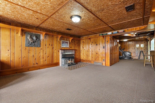 62 Robertson Ct, Clarkston, MI 48346 - basement featuring carpet flooring, wood walls, a wood stove, and baseboards