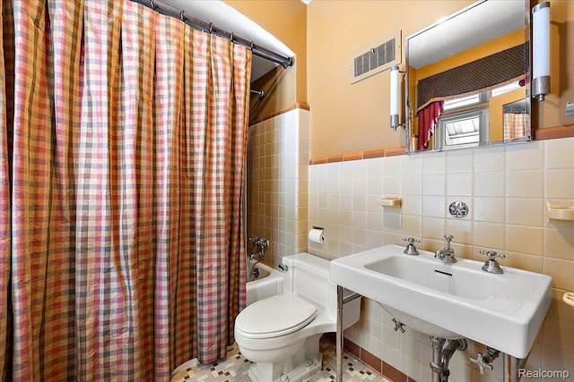 62 Robertson Ct, Clarkston, MI 48346 - full bathroom with tile walls, toilet, shower / bath combo with shower curtain, a sink, and wainscoting