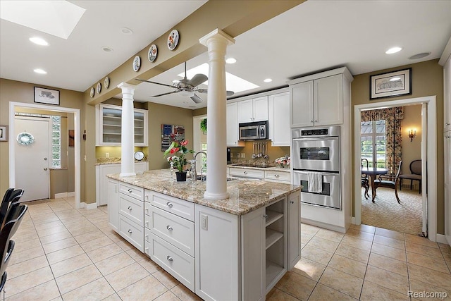 62 Robertson Ct, Clarkston, MI 48346 - kitchen with stainless steel appliances, ornate columns, open shelves, light tile patterned floors, and recessed lighting