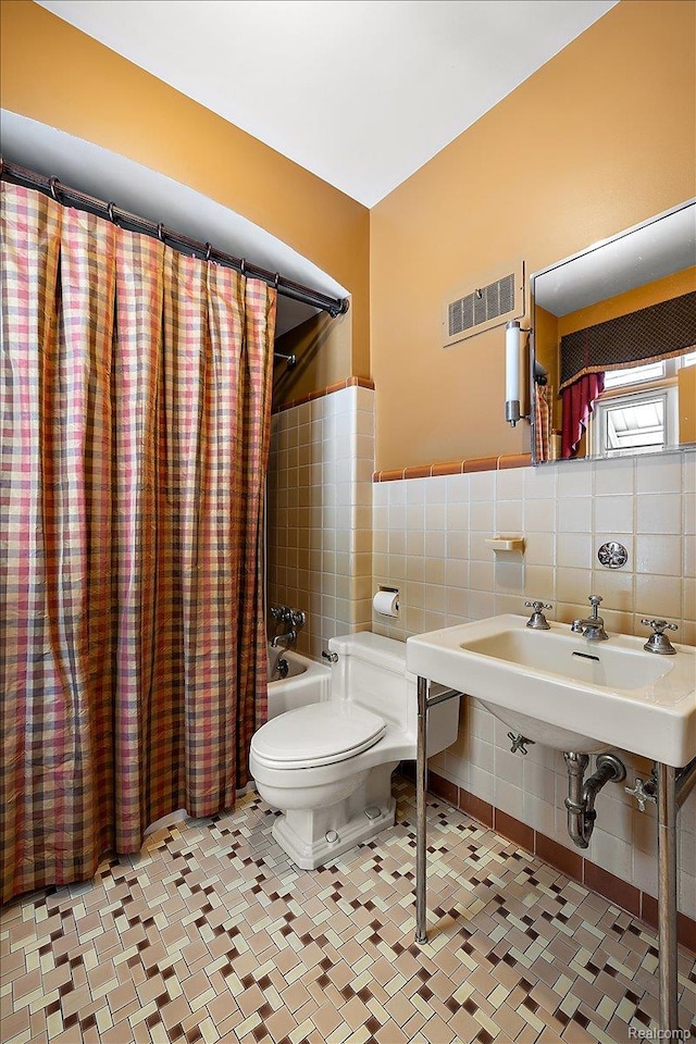62 Robertson Ct, Clarkston, MI 48346 - full bathroom with tile walls, toilet, and shower / tub combo