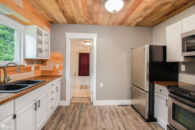 187 S Saginaw St, Montrose, MI 48457 - kitchen featuring stainless steel appliances, wood ceiling, light wood-style flooring, and white cabinetry