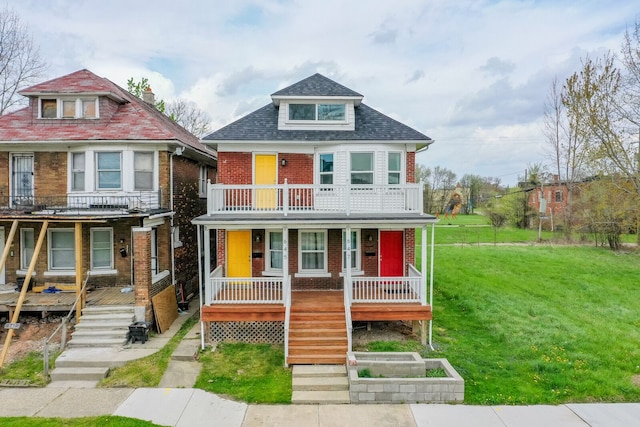 view of front of house featuring covered porch, stairway, brick siding, a balcony, and a front lawn
