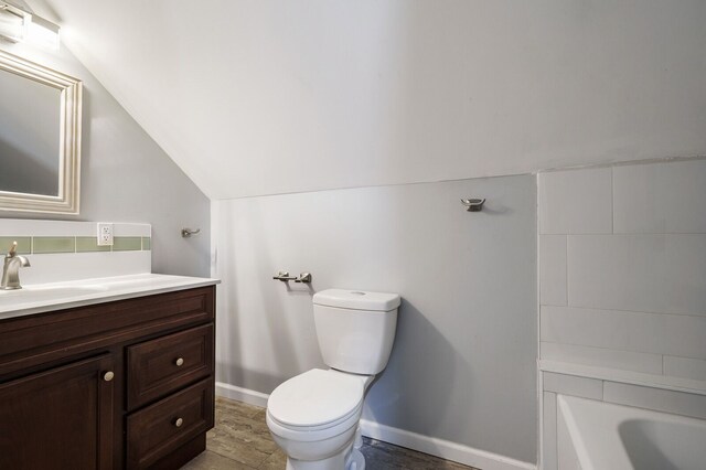 bathroom with vanity, baseboards, toilet, and lofted ceiling