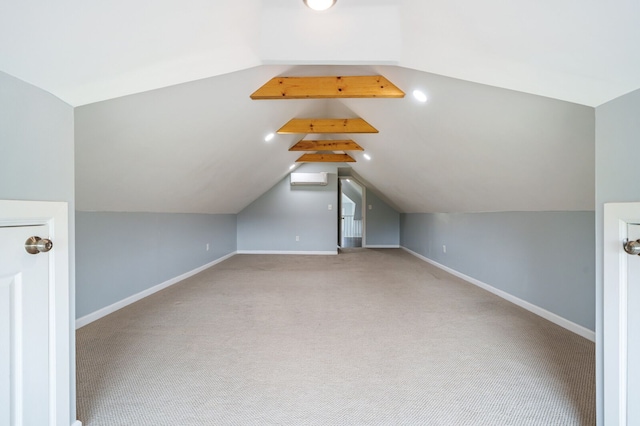 additional living space featuring carpet floors, baseboards, a wall unit AC, and lofted ceiling