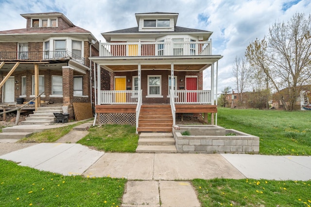 american foursquare style home featuring a balcony, a front yard, stairs, brick siding, and a porch
